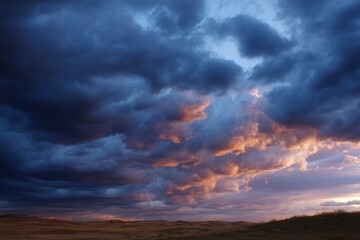 Fototapeta premium Dramatic Prairie Sunset: Dark Clouds and Glowing Hues