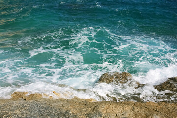 Ocean waves hitting rocks, sea foam, beach