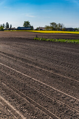 A rural landscape with a plowed empty field at the beginning of spring
