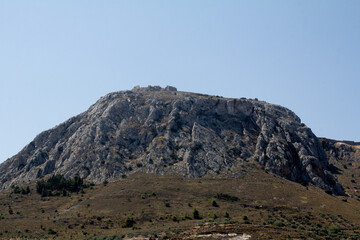 Capture the majestic silhouette of a Greek mountain, showcasing its rugged terrain and natural beauty.