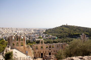 Fototapeta premium The Odeon of Herodes Atticus in the foreground with a sweeping view of Athens in the background. A blend of history and modern city life.