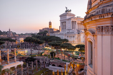Scenic view of a historic dome and ancient Roman ruins glowing in the sunset light. The iconic...