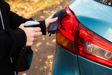 Car disinfection service. A woman disinfects and cleans the inner handle of the car door. Safety and prevention of infection with the Covid-19 virus, infection