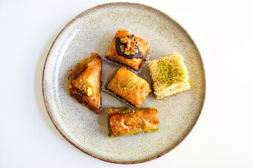 Pistachio, walnut and various other types of baklava on white background, top view