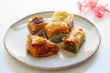 Pistachio, walnut and various other types of baklava on white background 
