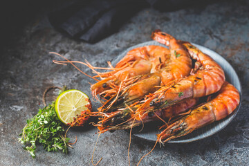 Giant fresh Tiger Prawns on plate over dark stone background