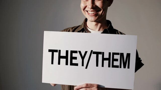 Inclusive identity expression with smiling person holding they/them sign