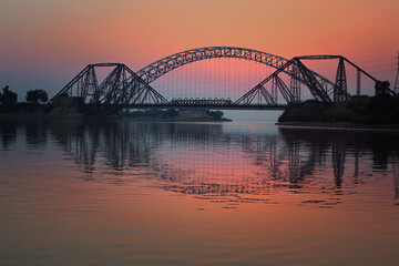 Naklejka premium Sun setting down on the Lansdowne Bridge at the Indus River, Sukkur, Sindh, Pakistan