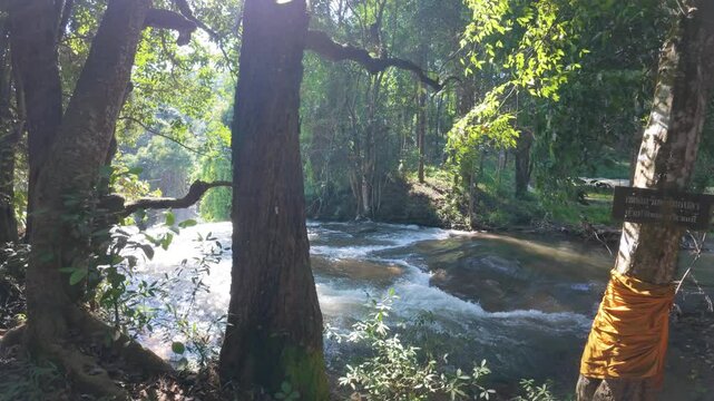 The Pha Dok Seaw Waterfall in Chiang Mai, Thailand, offers a serene view, with lush forest and flowing water enhancing the peaceful atmosphere.