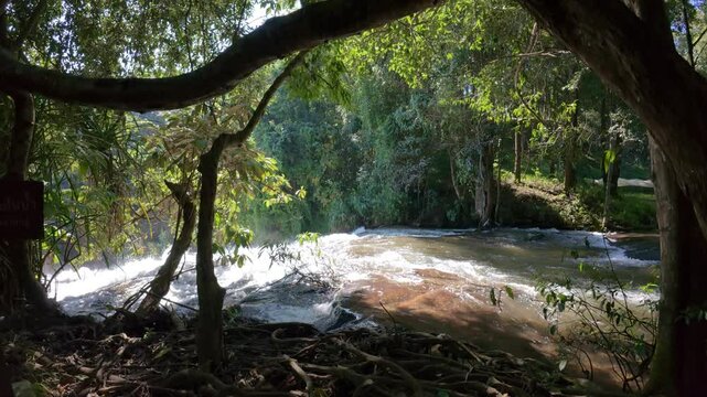The Pha Dok Seaw Waterfall in Chiang Mai, Thailand, offers a serene view, with lush forest and flowing water enhancing the peaceful atmosphere.