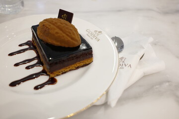 Indulgent Chocolate Layer Cake with Biscuit Garnish Served on Elegant Plate in Gourmet Setting