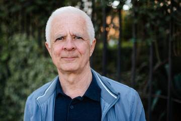 Senior man with gray hair 60-65 year old over nature background close up. Mature lifestyle. Looking...