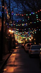 Colorful holiday lights illuminate a quiet city street at night.