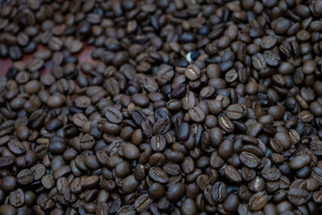 Roasted coffee beans forming a textured background for cafe and coffee shop promotion
