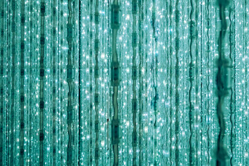 Turquoise hanging led lights creating wavy pattern background