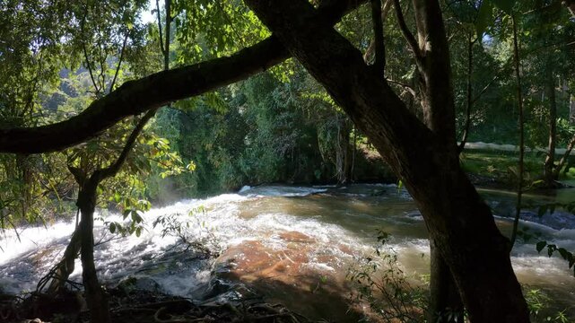 The Pha Dok Seaw Waterfall in Chiang Mai, Thailand, offers a serene view, with lush forest and flowing water enhancing the peaceful atmosphere.