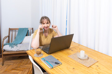 Mature woman on a call with laptop and coffee