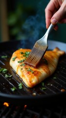 A person brushes marinade onto salmon fillet with chopped green onions on a sizzling grill, emphasizing fresh culinary preparation