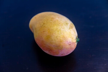 Ripe rosa mango isolated on uniform background. Brazilian fruit and food