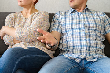 A couple shows conflict in a serious discussion on a couch, revealing their emotional struggle