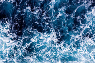 Ocean water surface texture. Aerial view of amazing water with foam. Can be used in covers, packaging, posters, textures, banners, art, and design projects. Enchanting nature background image.
