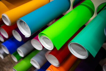 Rolls of self-adhesive film in different colors on the store shelf.Vinyl self-adhesive film for...