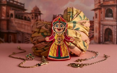 Fototapeta premium Spring, Jaipur, Rajasthan ,Spring in the Pink City, Indian embroidered figurine, turban, jewelry, pink background