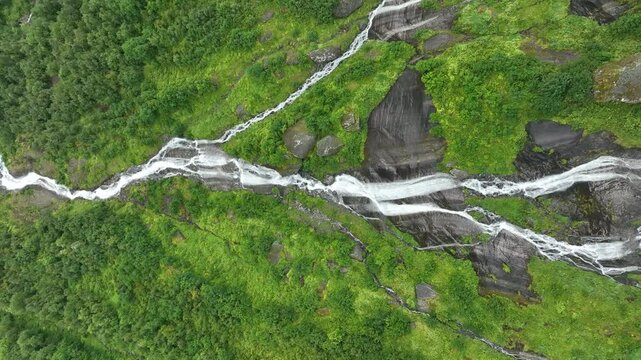 The falls of Vikagjolet Fossen streaming on moss-covered rocky terrain in Loen, Norway