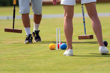 Obraz premium Players participating in a friendly croquet match on a sunny day in a park