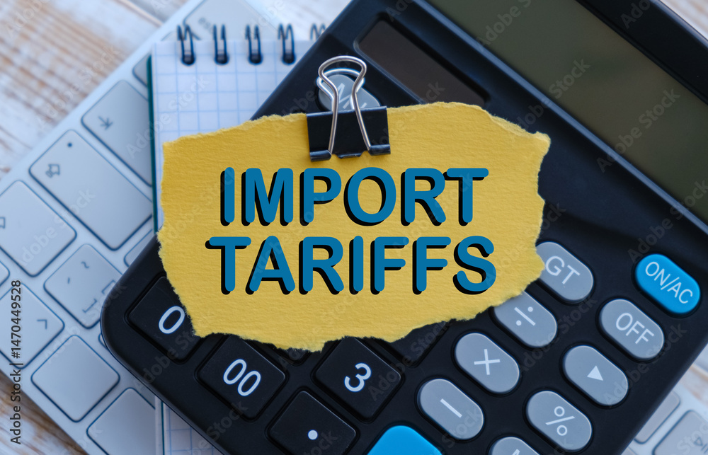 Fototapete a calculator sits on a desk with a piece of paper that says import tariffs on