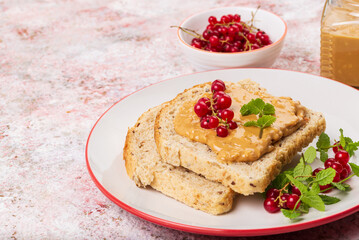 Breakfast with whole grain sandwich with peanut butter and red currant  close up