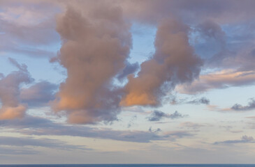 Fototapeta premium Cloudscape Over Ocean at Sunset Reflecting Warm Orange Hakus in Kailua-Kona, Hawaii