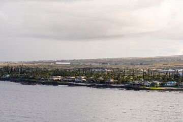 Naklejka premium Coastal Landscape of Kailua-Kona, Hawaii with Ocean and Houses Under Overcast Sky