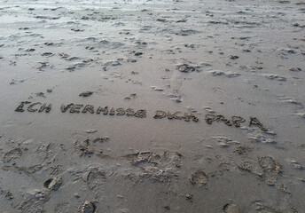 Lettering on the beach in the sand with I miss you dad