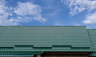 Green metal roof under a clear sky