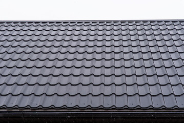 Shiny metal roofing sheet with scattered raindrops