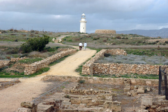 Maestoso panorama del sito archeologico di Paphos con le antiche fondamenta e i celebri mosaici della Casa di Dioniso che si estendono sotto un cielo primaverile verso il faro bianco e il mare