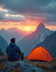 Fototapeta premium Person sits near tent overlooking stunning mountain range at sunrise. Enjoying serene view and tranquility of nature. Travel, adventure, exploration, holiday. Mountain peak, camping, hiking, tour.
