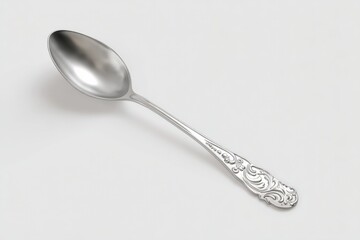Elegant silver spoon with ornate handle, isolated on white.
