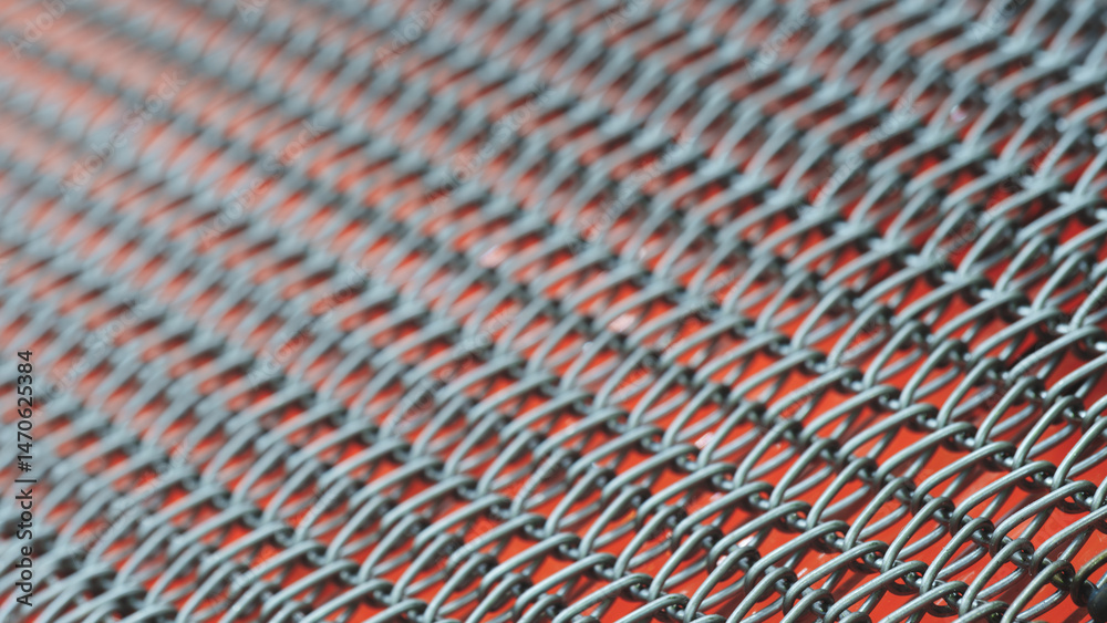 Poster a close up of a silver chain with red background. chain is made of metal and is very thin