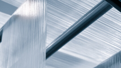 Obraz premium synthetic textile thread, thread at industrial weaving manufacturing machine, textile fabric production industrial concept background