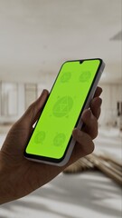 GREEN SCREEN CHROMA KEY A hand holding a smartphone with a green screen inside a renovated apartment