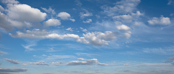 Fototapeta premium heaven sky is blue with a few clouds scattered throughout. The clouds are white and fluffy, giving the sky a peaceful and serene.
