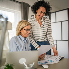 Two mature woman work and consult at office