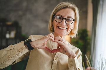 Portrait of one mature blonde caucasian woman with eyeglasses at home
