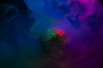 Vibrant stock image showcasing a disco ball at the center of a dynamic swirl of colors, surrounded by colorful smoke Suitable for advertising nightlife, parties, music events, or any lively and cele