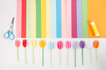 Creative flat lay with paper flowers and tools on white background, perfect for craft tutorials,...