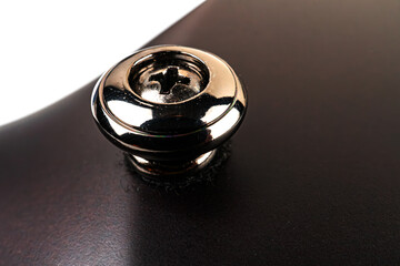 Image features an elegant, luxurious silver button with a diamond design against a black background...
