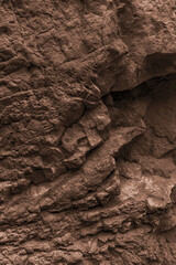 Textured rock surface reveals intricate layers and natural formations in a rugged outdoor landscape