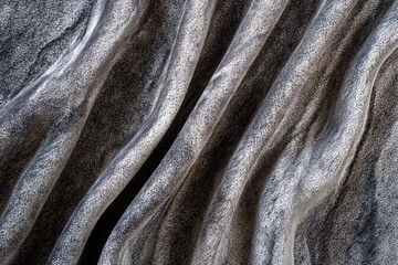 Textured Marble Waves: A close-up view of beautifully textured marble, showcasing flowing, organic waves of gray and white. A captivating abstract design, evoking elegance and natural beauty.